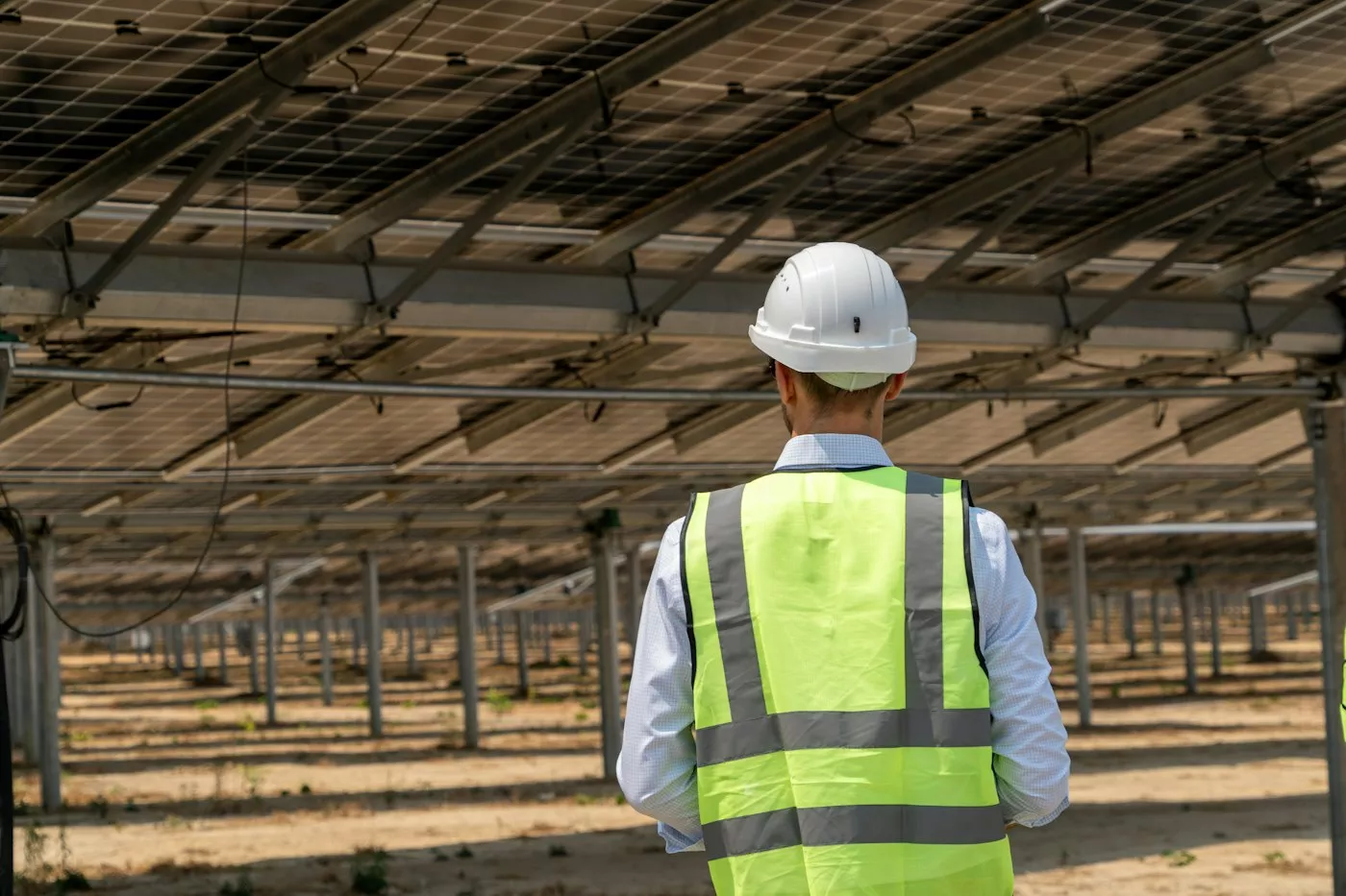Engineer in a hard hat inspecting a solar plant